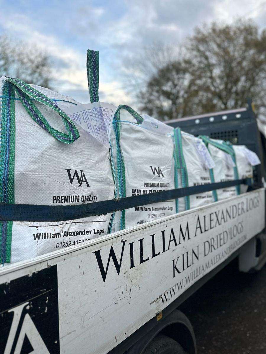 Bags of kiln-dried logs strapped down on a delivery van
